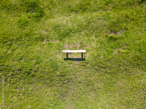 Aerial drone view. Bench on a green meadow.