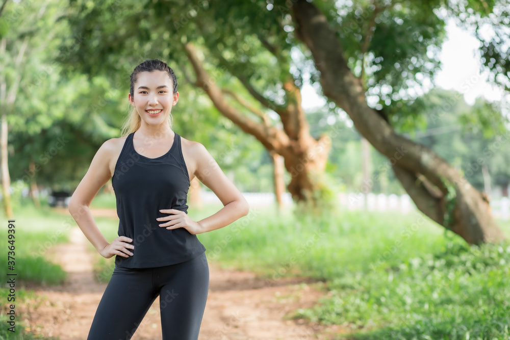 Asian women wear workout clothes at the park and are warming their bodies before exercising. Asian women wear workout clothes at the park and are warming their bodies before exercising.