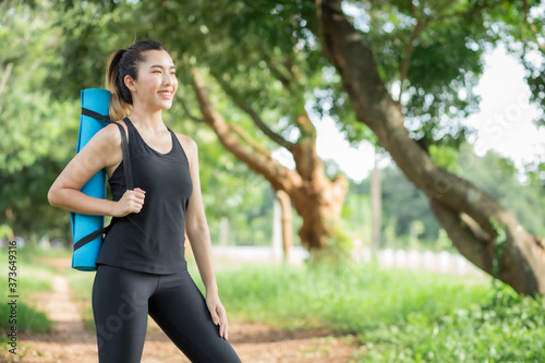Asian women holding yoga mats prepare to go out to yoga