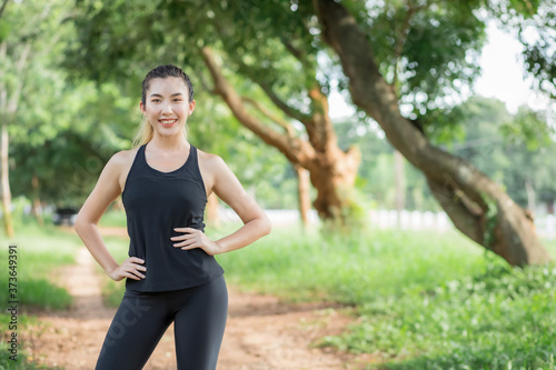 Asian women wear workout clothes at the park and are warming their bodies before exercising.