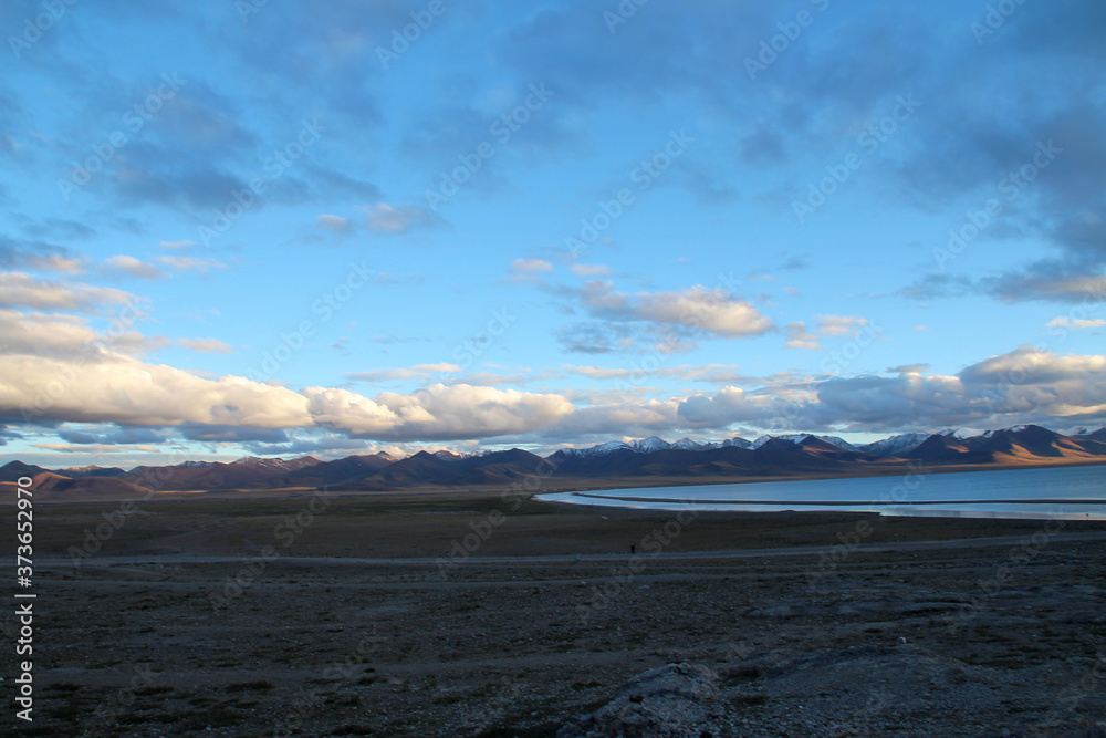 View of the sunset at Namtso lake with Tanggula Mountains and dramatic sky, Tibet, China