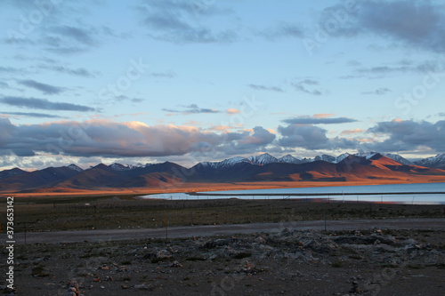 View of the sunset at Namtso lake with Tanggula Mountains and dramatic sky, Tibet, China photo