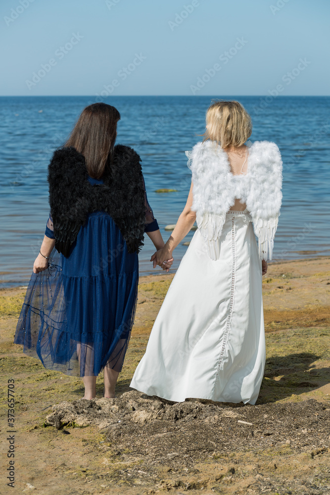 City Saulkrasti, Latvia. Two angels join hands walking along the sea shore.2 City Saulkrasti, Latvia. Two angels join hands walking along the sea shore.2
