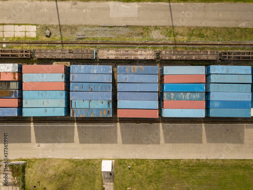 Multicolored freight containers on the railroad. Aerial drone view.