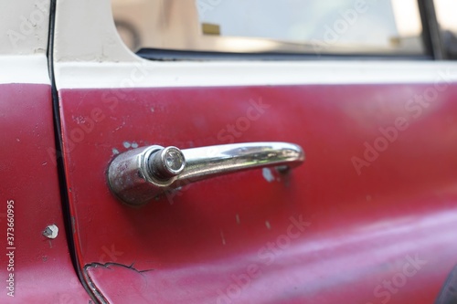 Close-up a Car door handle of a red vintage car.