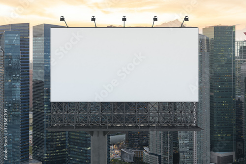 Blank white road billboard with Singapore cityscape background at sunset. Street advertising poster, mock up, 3D rendering. Front view. The concept of marketing communication to sell idea.