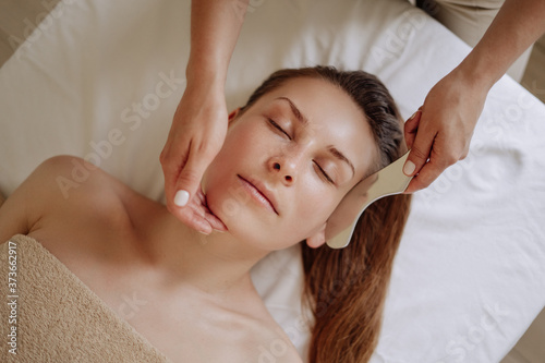 Massagist Massaging Client Face with Massager
