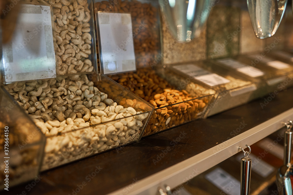 .Shelves with glass cells filled with nuts and cereals..Zero waste shopping concept