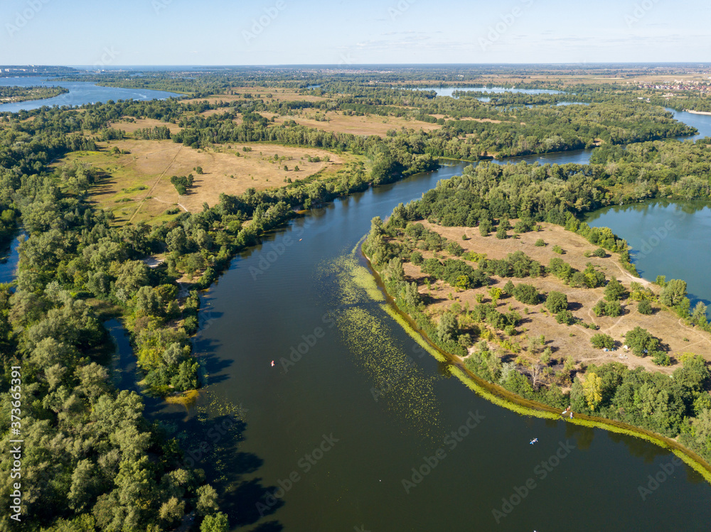Green bank of the Dnieper river on a summer sunny day. Aerial drone view.