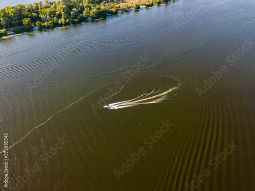 Motor boat in the Dnipro river. Sunny clear summer day. Aerial drone view.