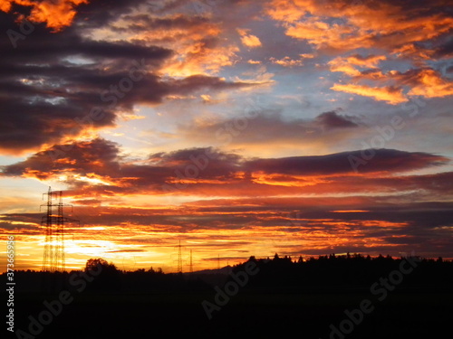 Big, 40 kW electric masts in bold sunset with clouds. © Primus_1
