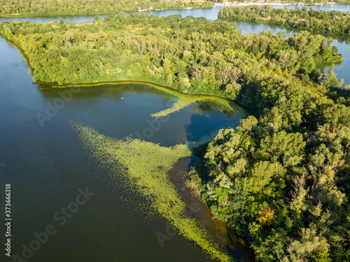 Green bank of the Dnieper river on a summer sunny day. Aerial drone view.
