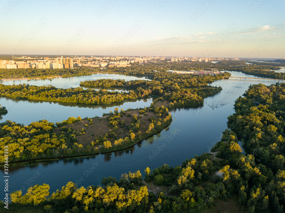 Aerial drone view. Bank of the Dnieper River in Kiev in the evening in the rays of the setting sun.