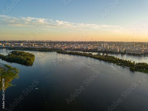 Aerial drone view. Bank of the Dnieper River in Kiev in the evening in the rays of the setting sun. © Sergey