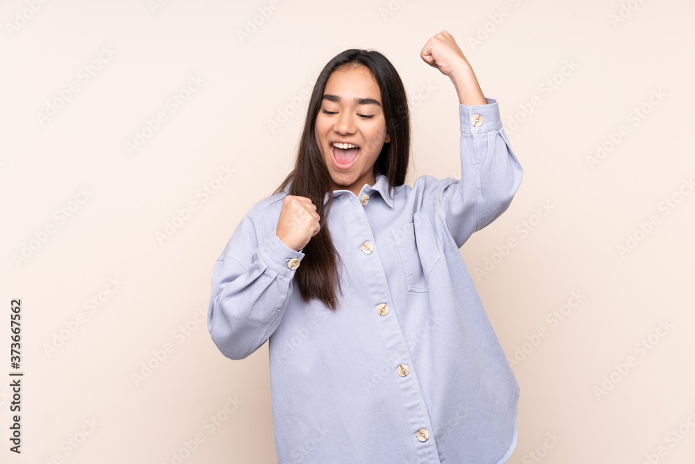 Young Indian woman isolated on beige background celebrating a victory Young Indian woman isolated on beige background celebrating a victory
