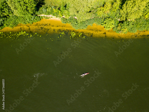 Kayak boat in the green water of the Dnieper river. Aerial drone view.