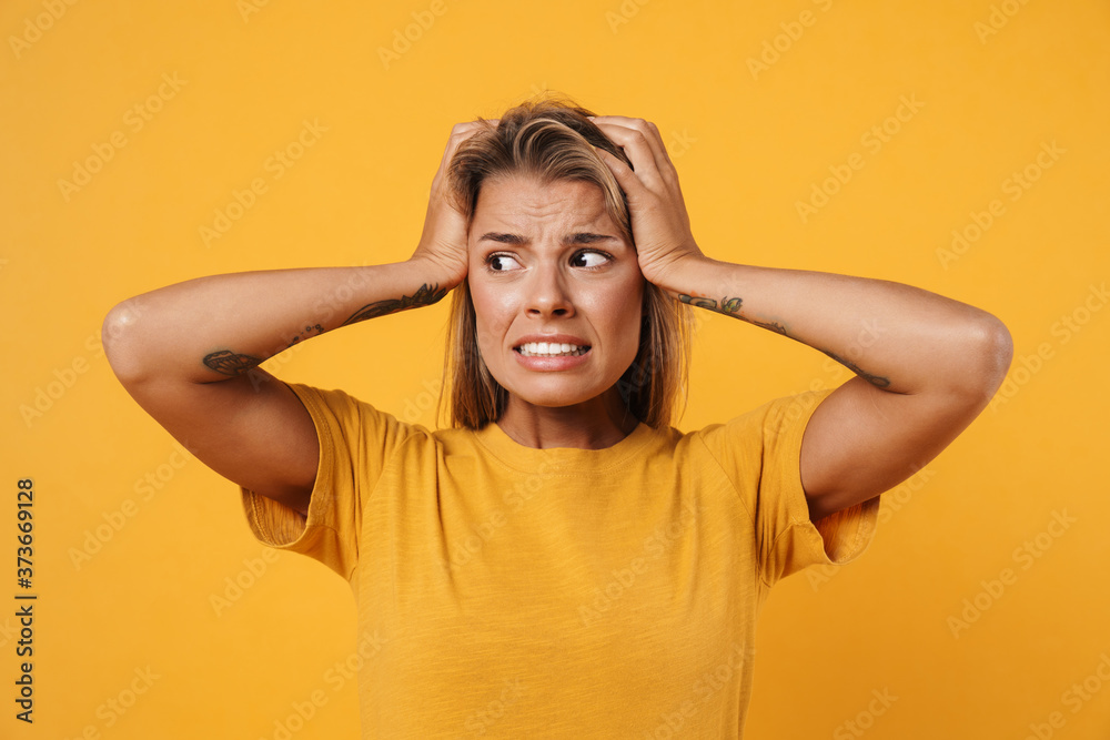 Image of scared woman looking aside and grabbing her head Image of scared woman looking aside and grabbing her head