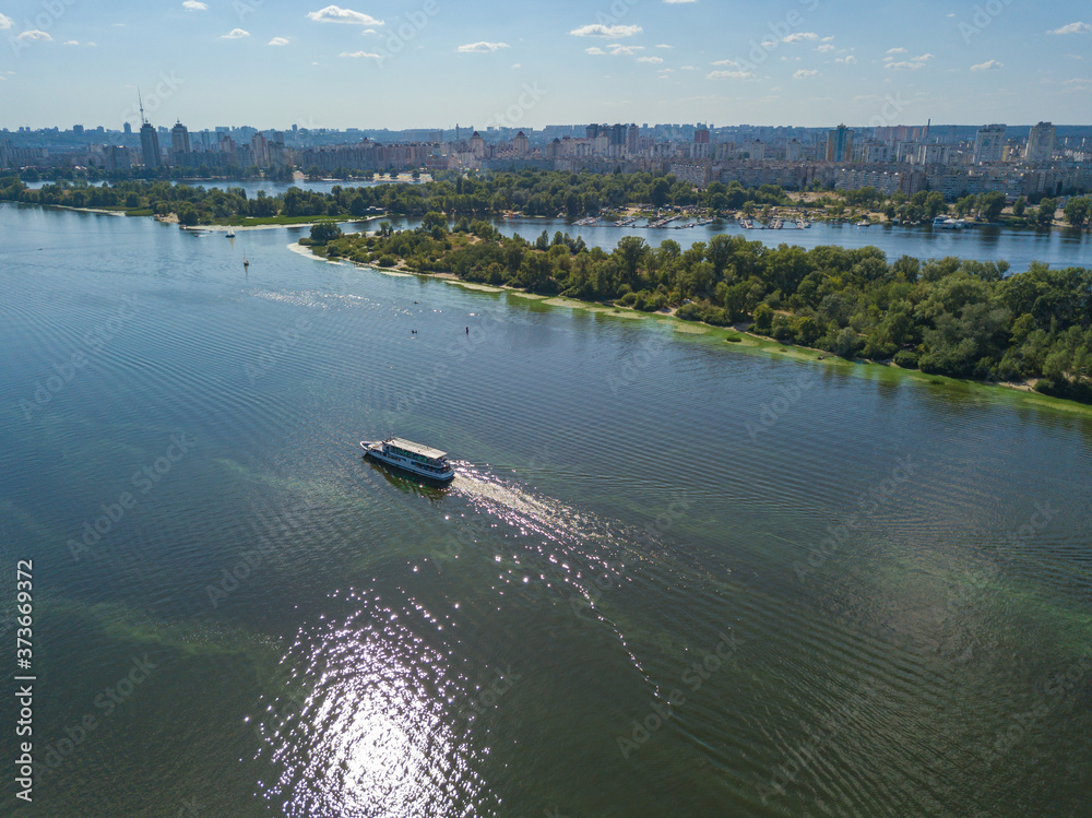 Obraz premium The boat sails along the Dnieper River in Kiev. Aerial view.
