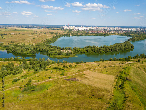 Aerial drone view. Green meadows by the river.