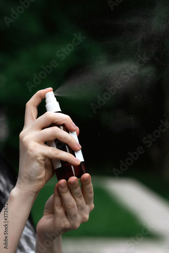 Close-up of female hands with a bottle of spray. Dysenfection, self-care. © Vita Monart