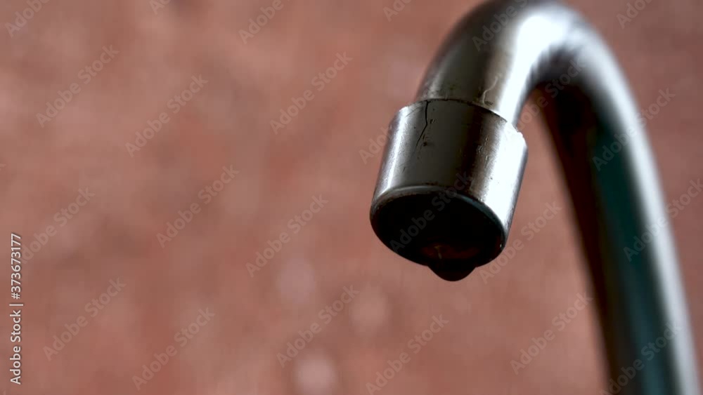 The old tap on the kitchen mixer is leaking. Tap water dripping. Daylight macro photography. The old tap on the kitchen mixer is leaking. Tap water dripping. Daylight macro photography.