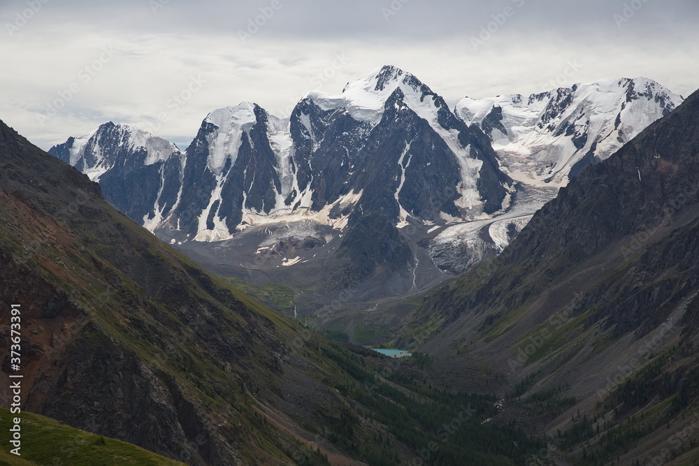 High mountains with a glacier. Mountain landscape in cloudy weather. Rainy weather in the mountains.