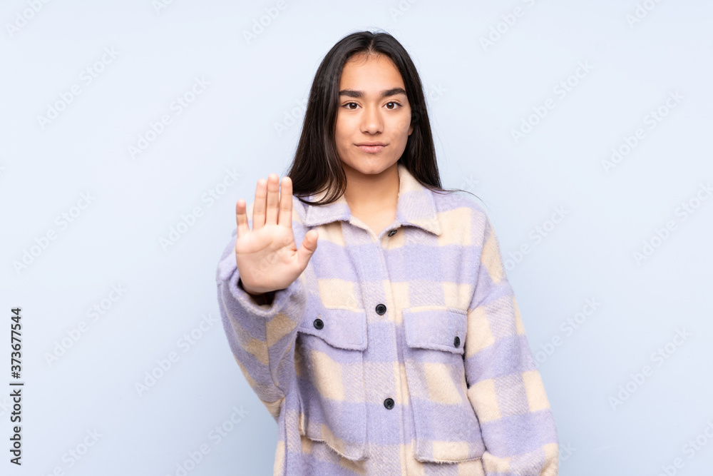 Young Indian woman isolated on blue background making stop gesture Young Indian woman isolated on blue background making stop gesture