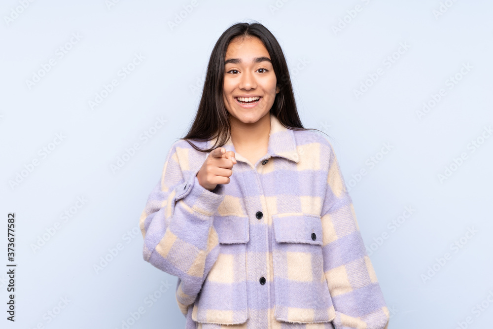 Young Indian woman isolated on blue background surprised and pointing front Young Indian woman isolated on blue background surprised and pointing front