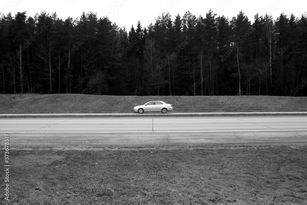 Moving car on asphalt road. black and white