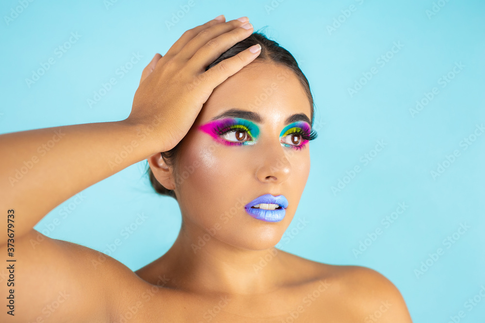 Naklejka premium Beauty portrait of female model with vivid makeup on blue background and blue lips.