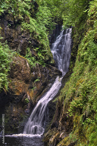 Glenariff Waterfall, Antrim, Northern Ireland. The Glenariff River tumbles over a high cliff covered with green vegetation in the picturesque Glens of Antrim.