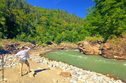 Female tourist looks down at a beautiful bend of the river White. Khamyshki, Adygea Republic, Russia photo