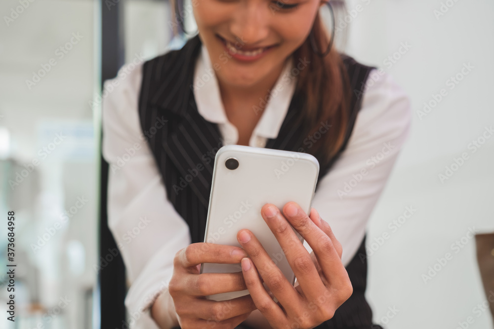 Cropped shot of professional female smiling while looking at smart phone Cropped shot of professional female smiling while looking at smart phone