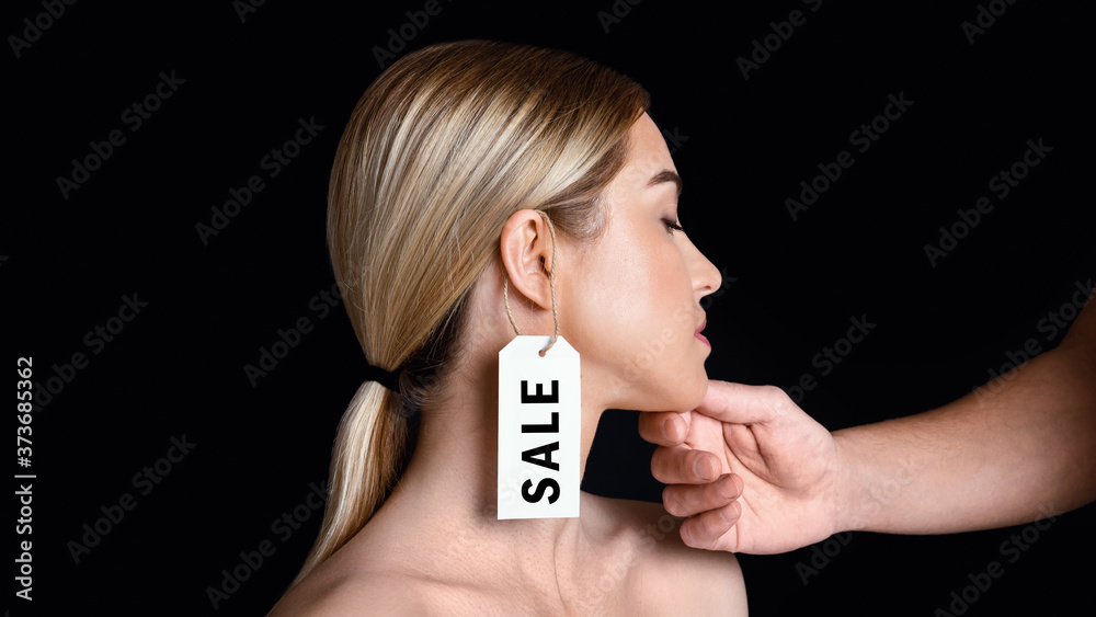 Weaker sex. Male hand touches to face of woman with label on ear with inscription sale Weaker sex. Male hand touches to face of woman with label on ear with inscription sale