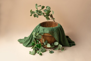 the wooden bucket is decorated with eucalyptus. props for newborn photo sessions. the branch of the eucalyptus. background for a photo shoot. furniture for dolls