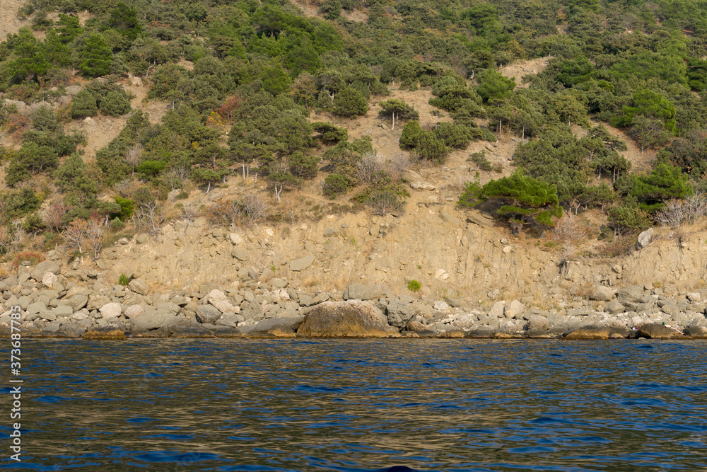 view from the sea on a rocky coastline view from the sea on a rocky coastline