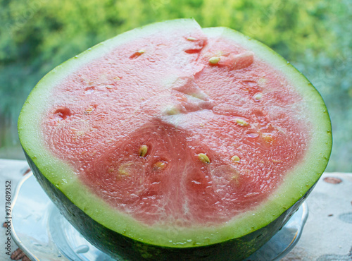 half of unripe watermelon with white seeds on the table