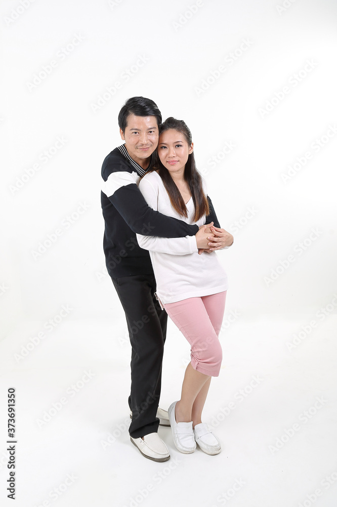 South East Asian young Chinese couple husband wife hung from behind look at camera happy smile hold hands love
