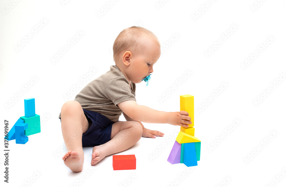 baby playing with toys on a white background. A funny little child plays with colorful cubes, baby playing with toys on a white background. A funny little child plays with colorful cubes,