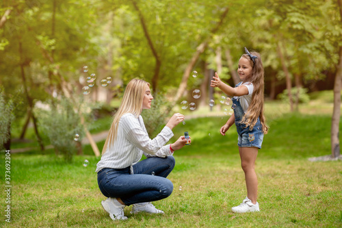 Mother And Little Daughter Having Fun With Soap Bubbles Outdoors © Prostock-studio