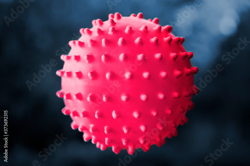 Кed rubber ball in the air against the background of a darkblue. Coronavirus.