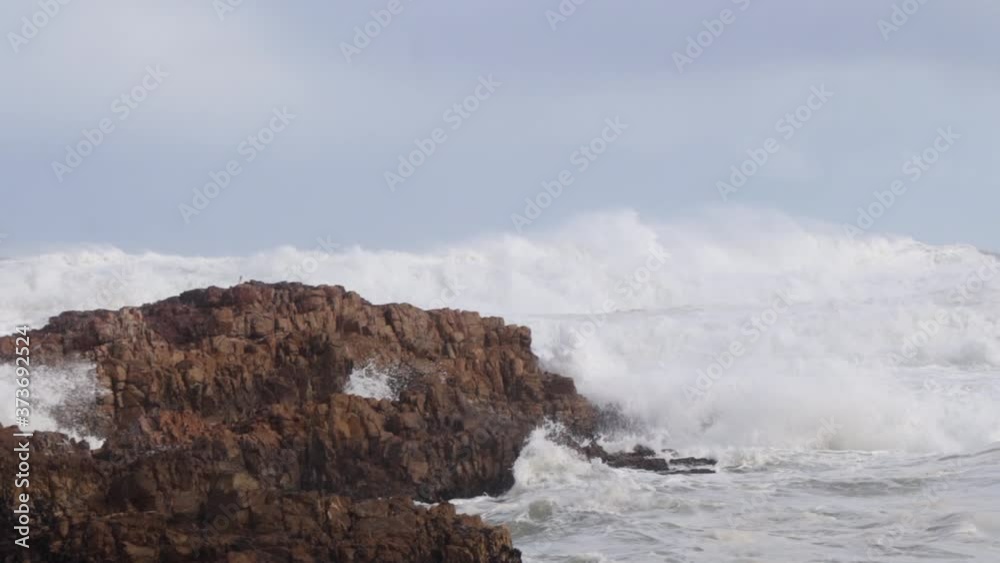 Wildly tumultuous whitewater shore break creates spray and sea foam Wildly tumultuous whitewater shore break creates spray and sea foam