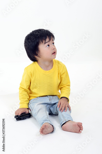 South East Asian young boy child playing looking up on white background