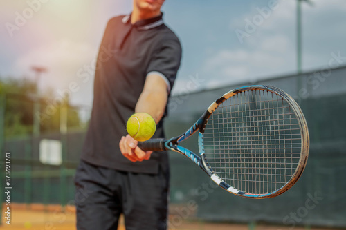 Close Up of Man Playing Tennis And Beating The Ball With a Racket. © Akaberka