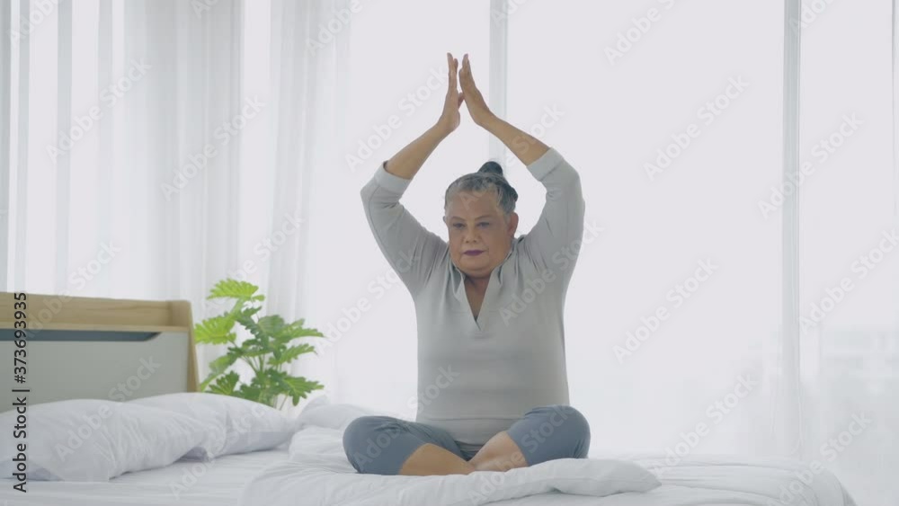 Holiday concept. Asian old woman doing yoga in bedroom. 4k Resolution. Holiday concept. Asian old woman doing yoga in bedroom. 4k Resolution.