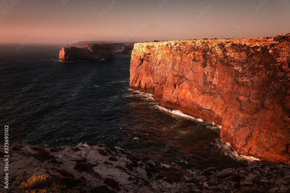 High red cliffs around Sao Vicente cape at south-west corner of Portugal, at the Algarve region.