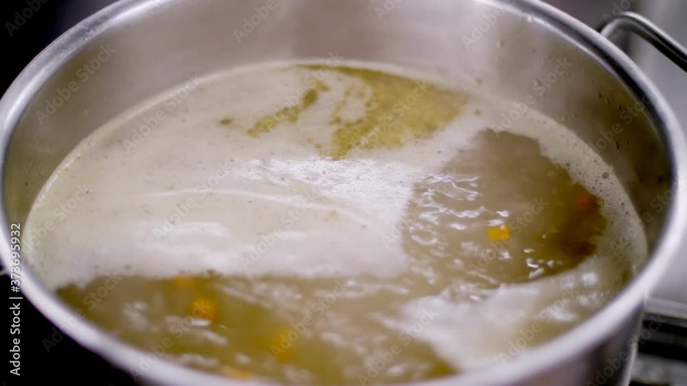 Cooking. close-up. broth is boiling in a saucepan, steam is coming. health food. safety concept. reopening canteen. volunteering and charity Cooking. close-up. broth is boiling in a saucepan, steam is coming. health food. safety concept. reopening canteen. volunteering and charity