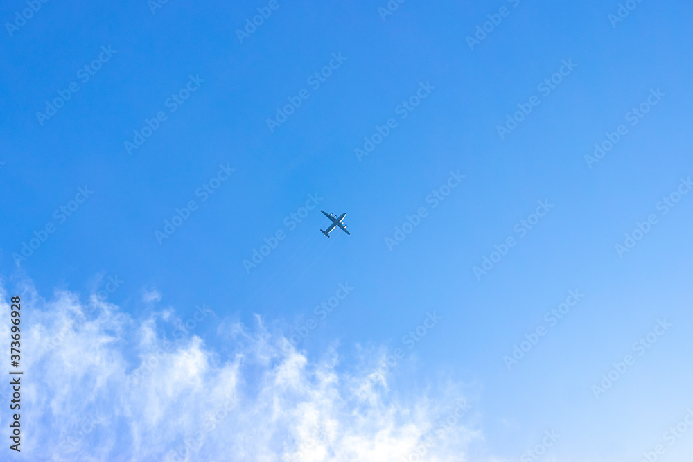 the plane flies among the clouds against the blue sky, leaving a trail behind it. The concept of ending the coronavirus pandemic and increasing air travel.