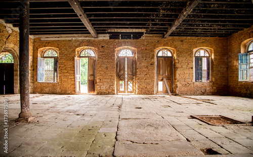 Gigantesca casa antiga abandonada, com chão de pedras e forro de madeira. Portas de madeira grandes e velhas com parede de tijolinhos grossa. photo