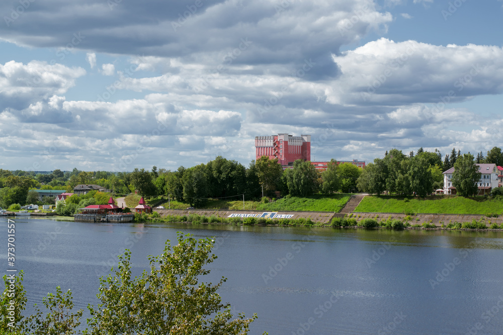 Kimry, Tver Region, Russia - August 19, 2020: View of the left bank of the small town Kimry from the bridge. The building of the theater and the embankment on a sunny day Kimry, Tver Region, Russia - August 19, 2020: View of the left bank of the small town Kimry from the bridge. The building of the theater and the embankment on a sunny day